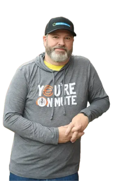 Roy with a shirt that says You're On Mute and a Tech Troublemaker baseball cap